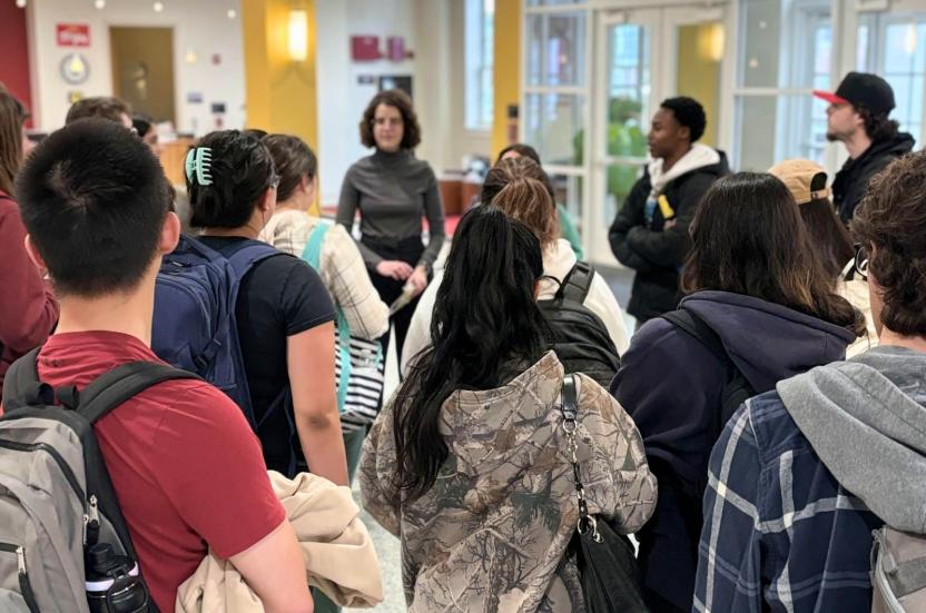 A group of students standing and listening to the instructor