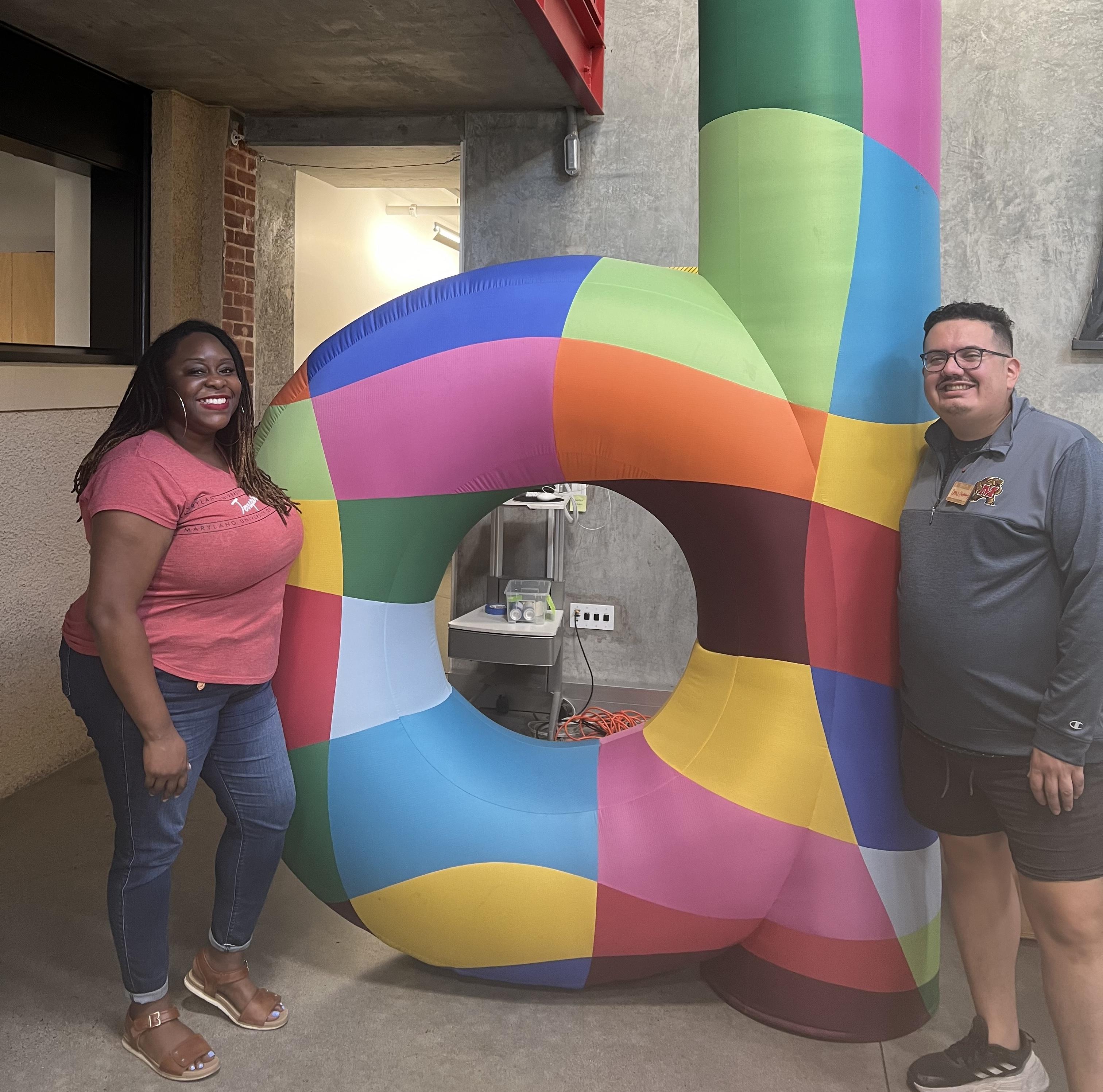 Denis Garcia Reyes and Michelle Udeli stand on opposing sides of a sculpture